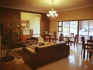 a living room with a couch and a table and chairs at Belmont Guesthouse in Bloemfontein