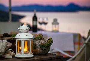 a lantern sitting on a table with a bottle of wine at Ethaleia Hotel in Moúdhros