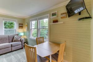a living room with a table and a tv on a wall at Bay View Bungalow in Poulsbo