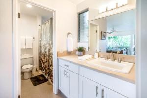 a bathroom with a sink and a toilet and a mirror at SandPiper #116a in Princeville +24 photos