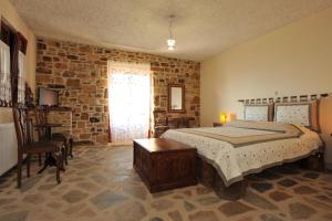 a bedroom with a bed and a brick wall at Ethaleia Hotel in Moúdhros
