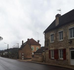 une rue vide avec des maisons sur le côté de la route dans l'établissement Chambres d'hôtes la Chaumière, à Arcy-sur-Cure