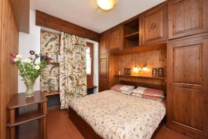 - une chambre avec un lit et un vase de fleurs dans l'établissement Residence Castelli, à Breuil-Cervinia