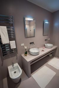 a bathroom with two sinks and a toilet and a mirror at Laura Family Apartments in Rome
