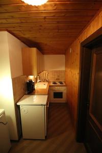 eine kleine Küche mit weißen Geräten und Holzwänden in der Unterkunft Ferienwohnung Krennbauer in Öblarn