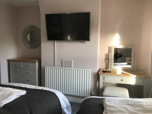 um quarto com uma cama e uma televisão na parede em Prince of Wales Marlow em Marlow