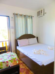 a bedroom with a bed with flip flops on it at Nanette's Tourist Inn in Bantayan Island