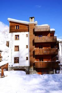a building with snow in front of it at Residence Castelli in Breuil-Cervinia