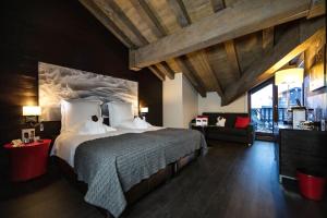 a bedroom with a large bed and a couch at Avenue Lodge Hotel & Spa in Val-d'Isère +37 photos