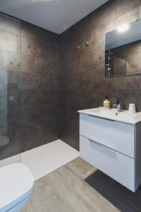 Un baño con lavabo blanco y ducha en La Chalana, en Corralejo