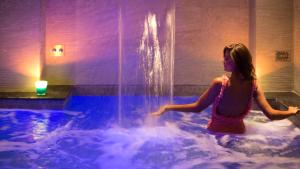 a girl in a hot tub with a fountain at Hotel Crawford in Sant'Agnello