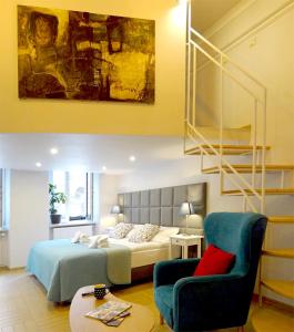 een slaapkamer met een bed en een stoel bij Art Apartments w centrum Krakowa (Śródmieście, Stradom) in Krakau