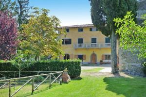 a large yellow house with a fence in front of it at Fattoria I Tribbi in Ambra