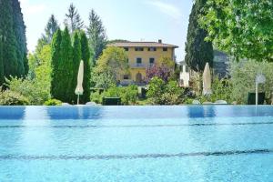 a large swimming pool with a house in the background at Fattoria I Tribbi in Ambra
