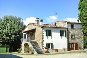 a large stone house with stairs and potted plants at Fattoria I Tribbi in Ambra