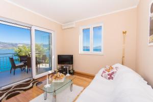 ein Wohnzimmer mit einem weißen Sofa und einem Glastisch in der Unterkunft Luxury Apartment L&A in Trogir