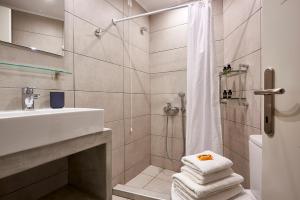 a bathroom with a shower, toilet and sink at Kythnos Bay Hotel in Loutra