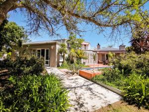 an exterior view of a house with a garden at Erinvale Garden cottage in Somerset West