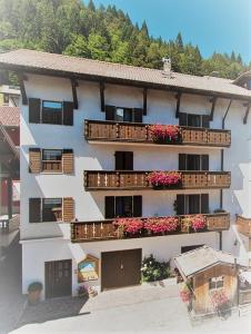 an apartment building with balconies and flowers on it at CASA MIFEL -- APP. GERANIO in Folgaria