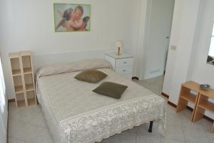 a bedroom with a bed and a table and a picture at Appartamento CRISTALLO 25 in Lignano Sabbiadoro