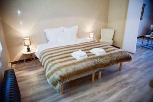 ein Schlafzimmer mit einem großen Bett mit zwei Handtüchern darauf in der Unterkunft La Meunière in Saint-Martin-Boulogne + 2 Fotos