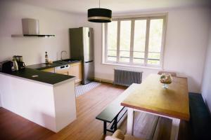 uma cozinha com um balcão e uma mesa num quarto em La Meunière em Saint-Martin-Boulogne