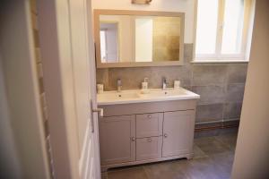 ein Badezimmer mit einem weißen Waschbecken und einem Spiegel in der Unterkunft La Meunière in Saint-Martin-Boulogne