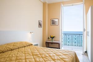 a bedroom with a bed and a balcony at Hotel Badano sul Mare in Alassio