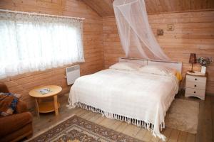 a bedroom with a bed in a wooden cabin at Lepametsa Holiday Houses in Nasva