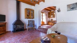 salon z kanapą i piecem opalanym drewnem w obiekcie Country House Banyols w mieście Alaró