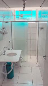 uma casa de banho branca com um lavatório e um WC em Rota Hoteis Uberlandia em Uberlândia