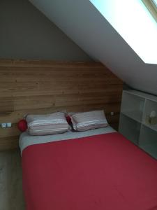 a bed with two pillows on it in a attic at Le Gîte de la Maison Soleil, entre lac et montagne in Alex