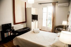 a bedroom with a bed and a kitchen with a window at La Casa di Caterina in Lefkada