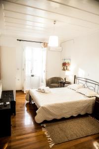 a white bedroom with two beds and a window at La Casa di Caterina in Lefkada Town