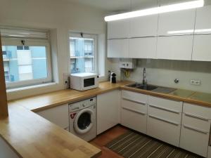 een keuken met een wasmachine en een magnetron bij Matosinhos Beach Apartment in Matosinhos