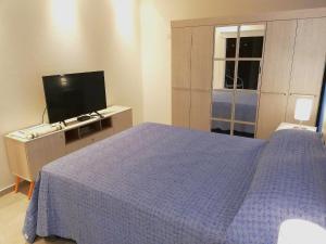 コルドバにあるAltos de Chacabuco Planta Alta Apartamento temporario amoblado premium con cochera gratisのベッドルーム(青いベッド1台、テレビ付)