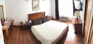 En eller flere senge i et værelse på Hotel Galerias Pasto