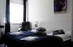1 dormitorio con cama con almohadas y ventana en Kanns Hotel, en Åkirkeby