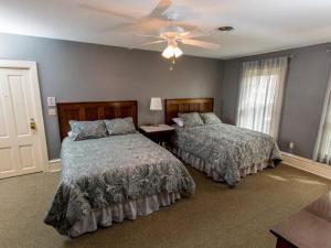 a bedroom with two beds and a ceiling fan at Victoria Inn in Erie