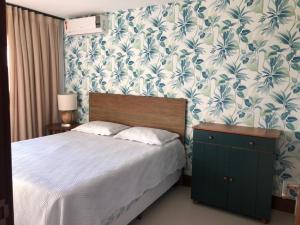 a bedroom with a bed with a blue and white wallpaper at Casa 4 Quartos Praia do Forte in Praia do Forte +27 photos