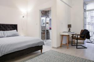 a bedroom with a bed and a desk and a chair at 88, Valletta Boutique Escape in Valletta