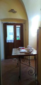 a table in the middle of a room with a door at BB Dimora San Pietro in Ferrandina