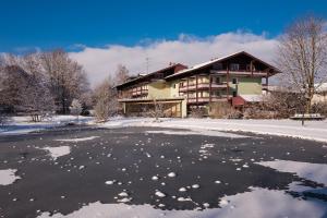 uma casa num lago congelado na neve em Thermenhotel Ströbinger Hof em Bad Endorf
