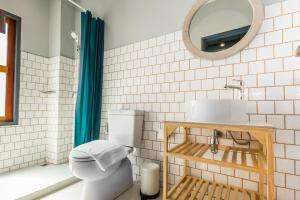 a bathroom with a toilet and a sink and a mirror at Mimi and Jim Co-living space in Cha Am