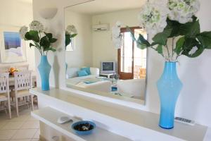 een woonkamer met twee blauwe vazen met bloemen op een tafel bij VILLA EVANTHIA in Bouzéïka