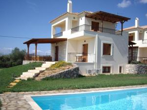 a house with a swimming pool in front of it at VILLA EVANTHIA in Bouzéïka