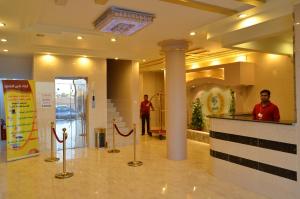 a lobby with two people standing in a building at Zahrt Nadeen in Tabuk