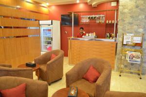 a barber shop with chairs and a woman in the mirror at Zahrt Nadeen in Tabuk