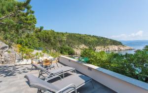 a balcony with chairs and a view of the water at Seafront Apartment With Amazing Seaview in Vrbnik