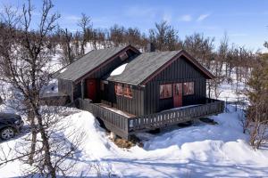 una baita di tronchi nella neve con neve di Torsetlia Cottages and Apartments a Uvdal